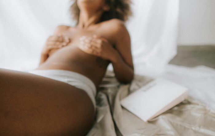 Mujer sonriente y relajada disfrutando de bienestar íntimo con confianza.